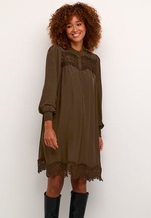Robe marron, longueur genoux, avec manches ballons, bouton devant et dentelle au bas. Fabriquée dans un tissu lisse avec une coupe décontractée.