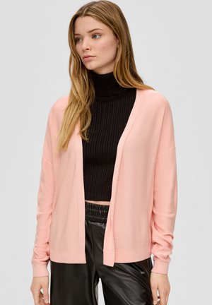 Roze gebreide cardigan met een losse pasvorm, met een open voorkant, lange mouwen en geribbelde boorden, gelaagd over een zwarte geribbelde coltrui.