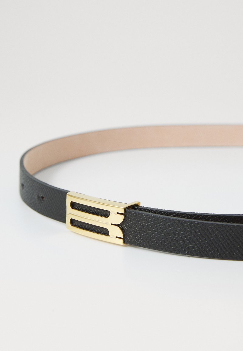 Sort læderbælte med en struktureret overflade, der har en gylden metalspænde med et dobbeltskinne-design. Glat inderside, ingen synlige mønstre.