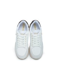 Sneakers bianchi con tomaia in sintetico liscio, linguetta imbottita e design con lacci. Marchio dorato e dettagli marroni sul tallone. Suola in gomma.