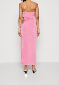 Różowa, welurowa sukienka maxi z dopasowanym gorsetem, cienkimi ramiączkami i bocznym wycięciem, charakteryzująca się gładką fakturą i długością do podłogi.