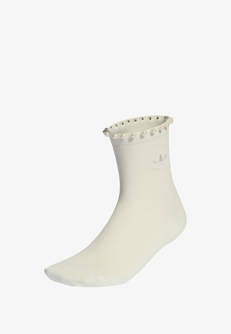 Biała skarpetka do kostki z fakturowanym wzorem, z mankietem ozdobionym perłami oraz małym wytłoczonym logo z boku.