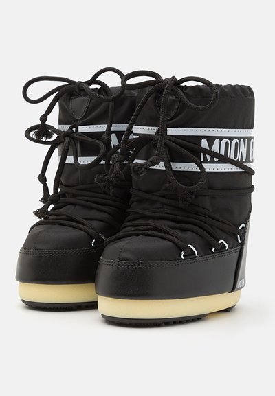 Black waterproof boots with rounded toe, thick white sole, and contrasting white straps. Features lace-up design with toggle closures.