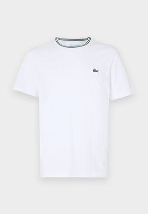 Weißes Baumwoll-T-Shirt mit kurzen Ärmeln und geripptem Kragen, der grüne und schwarze Streifen hat; kleines grünes gesticktes Logo auf der linken Brust.
