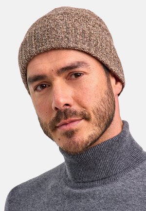Brown knit beanie with a textured ribbed pattern, paired with a gray turtleneck sweater. The hat fits snugly, covering the ears.