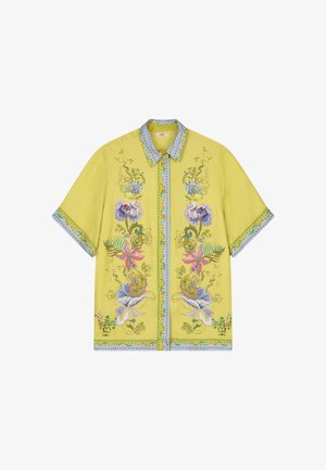 Geel shirt met korte mouwen, blauwe bies en gedetailleerde kleurrijke bloemenborduursels langs de voorkant, kraag, mouwen en zoom.