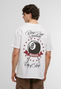 Biely bavlnený tričko s krátkym rukávom, na zadnej strane s veľkým viacfarebným grafickým zobrazením biliardovej gule a textom, zvýrazneným hviezdami.