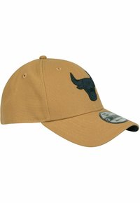 Beige baseball cap made of cotton, featuring a black embossed bull logo on the front, a curved brim, and ventilation eyelets.