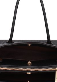 Sac à main en cuir noir avec une surface texturée, deux poignées et une fermeture éclair. L'intérieur présente une doublure en tissu lisse et une fermeture éclair dorée.