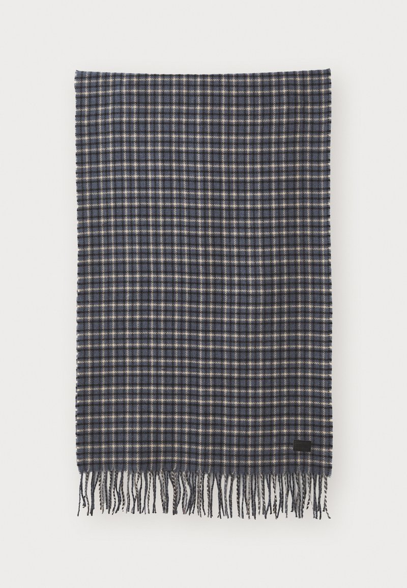 Woven wool scarf in dark navy and cream plaid, featuring fringe edges and a small black label accent. Soft texture with a rectangular shape.