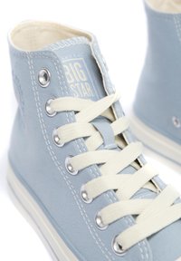 Zapatillas altas de lona azul claro con ojales blancos, cordones crema y un acabado texturizado. Presenta el logo "BIG STAR" en el lateral.