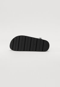 Talpa de sandale negre cu textură striată, margine curbată și striuri orizontale pentru aderență. Design minimalist, potrivit pentru ținute casual.
