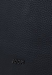 Materiale in pelle nera testurizzata con una finitura a motivo, caratterizzato da un logo metallico "JOOP!" di tonalità argento in basso.