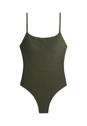Olivovo zelené jednoczęstné plavky s tenkými ramienkami a vysokým strihom nohavíc na bielom pozadí.