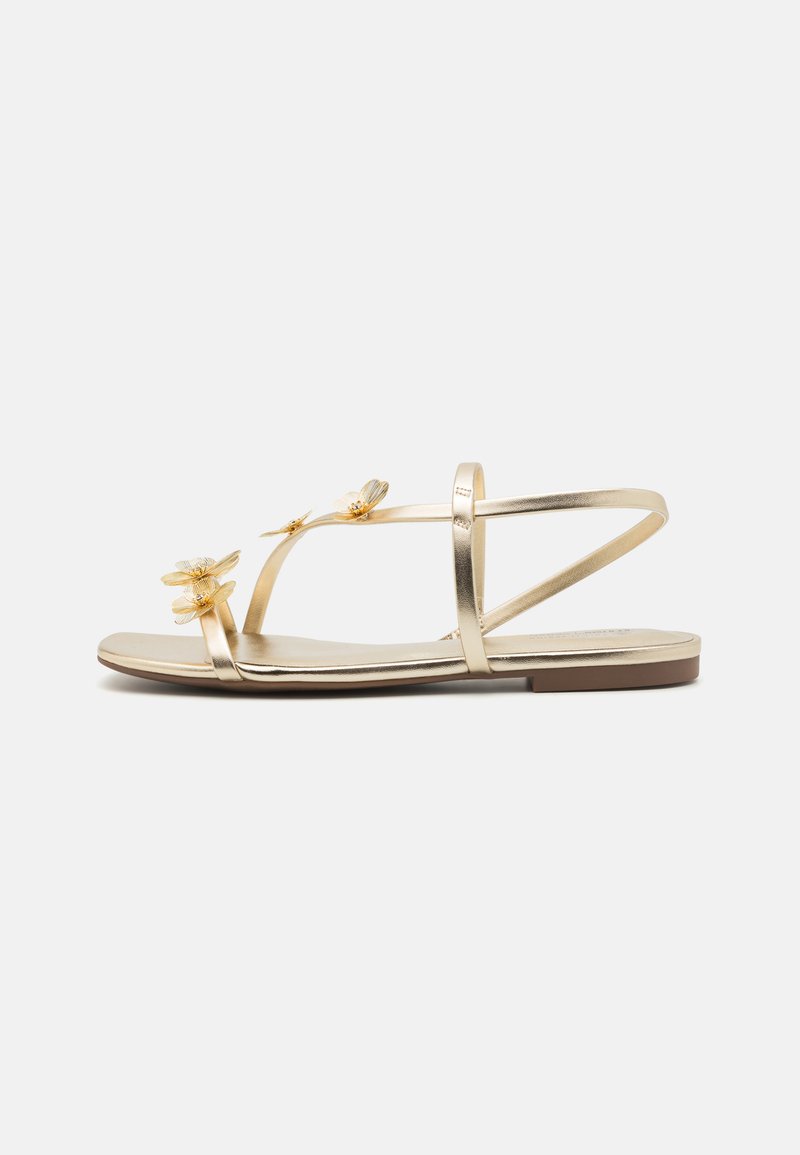 Golden flat sandals featuring three flower accents, slim metallic straps, and a smooth, flat sole with a minimalist design.
