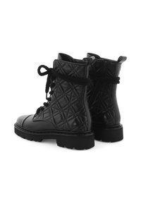 Bottines en cuir matelassé noir avec bout rond, lacées à l'avant et semelle épaisse ; avec des sangles d'épaule et des zips sur le côté pour un enfilage facile.