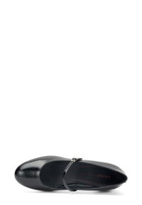 Zapato de cuero negro con punta redondeada y una delgada correa ajustable en el tobillo. Textura suave y discreta marca en la plantilla.