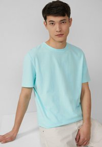 Lichtblauwe katoenen T-shirt met een ronde halslijn en korte mouwen, met een gladde textuur en een ontspannen pasvorm. Eenvoudig ontwerp, geen patronen.