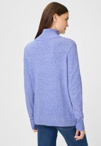 Lila Strickpullover mit hohem Kragen und gerippten Bündchen, der eine weiche Textur und eine lockere Passform aufweist, von hinten betrachtet.