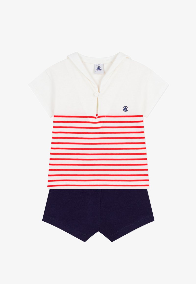 Completo in cotone con maniche corte composto da una maglietta bianca a righe orizzontali rosse e pantaloncini blu navy. Include un bottone e un logo a forma di barca a vela.