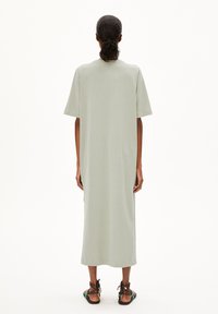 Helles grünes, knielanges Kleid aus weichem Stoff mit kurzen Ärmeln und geradem Schnitt. Minimalistisches Design ohne Muster oder Verzierungen.
