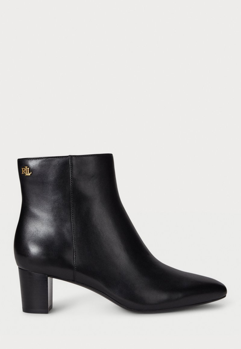 Black leather ankle boot with a pointed toe and a block heel. Features a gold logo detail on the back. Smooth texture with a sleek design.