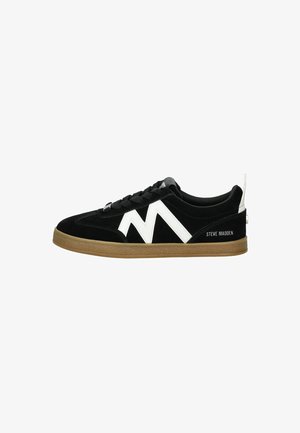 Sneaker in suede nero con design a zigzag bianco, chiusura con lacci e suola in gomma beige. Presenta il logo sul tallone e motivi testurizzati.
