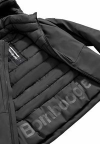 Giacca imbottita nera con materiale esterno liscio. Presenta una cerniera, una stampa del logo interna e una texture trapuntata nella fodera.