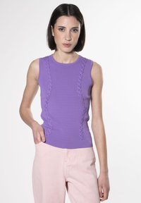 Top senza maniche color lavanda con linee verticali testurizzate e accenti volant sui lati, abbinato a pantaloni a gamba larga color rosa chiaro.