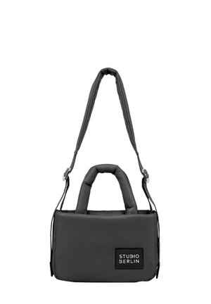 Schwarze gepolsterte Handtasche mit doppelten Griffen und einem abnehmbaren Schultergurt. Sie hat eine rechteckige Form und ein Logo-Patch auf der Vorderseite.