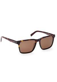 Occhiali da sole tortoiseshell marroni con montatura quadrata, lenti polarizzate marroni e un marchio discreto sulla tempia. Finitura brillante e superficie liscia.