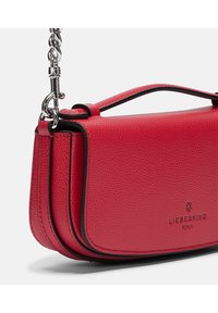 Czerwona torebka skórzana o fakturze z czarnym wykończeniem, o wyraźnej strukturze, z rączką u góry oraz odczepianym srebrnym łańcuszkiem.