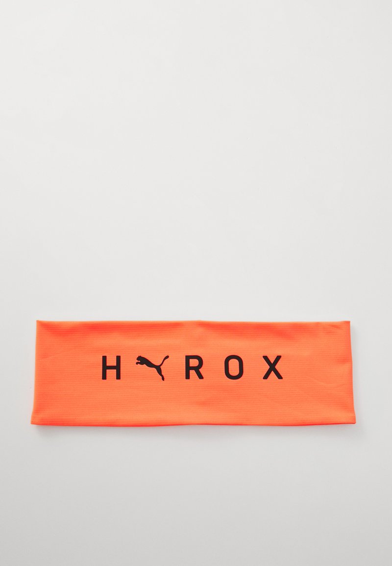 Un bandeau de sport orange vif en matériau extensible, arborant le texte noir "HYROX" et un petit logo noir. Texture lisse, forme rectangulaire.