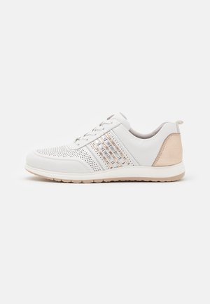 Witte lage sneaker met geperforeerde neus, zilveren en beige accenten, vetersluiting en beige zool op witte achtergrond.