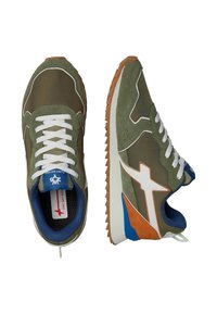 Scarpe sportive verdi con tomaia in suede e tessuto, dotate di lacci bianchi, accenti blu e suola in gomma. Dettagli di design a contrasto eleganti.