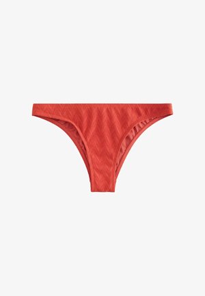 Slip bikini rosso con motivo a zigzag testurizzato, caratterizzato da un taglio a vita bassa e una fodera liscia. Nessun elemento metallico o decorativo visibile.