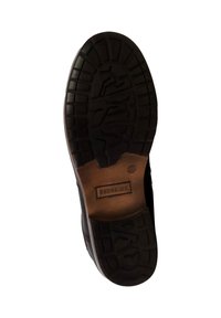 Suela de zapato de goma negra con patrones de relieve profundos, que presenta una zona de cuero suave cerca del talón marcada con "REDSKINS."
