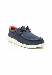 Zapatos de lona azul marino con punta redondeada, suela de goma blanca, forro interior naranja y dos ojales de metal para los cordones.