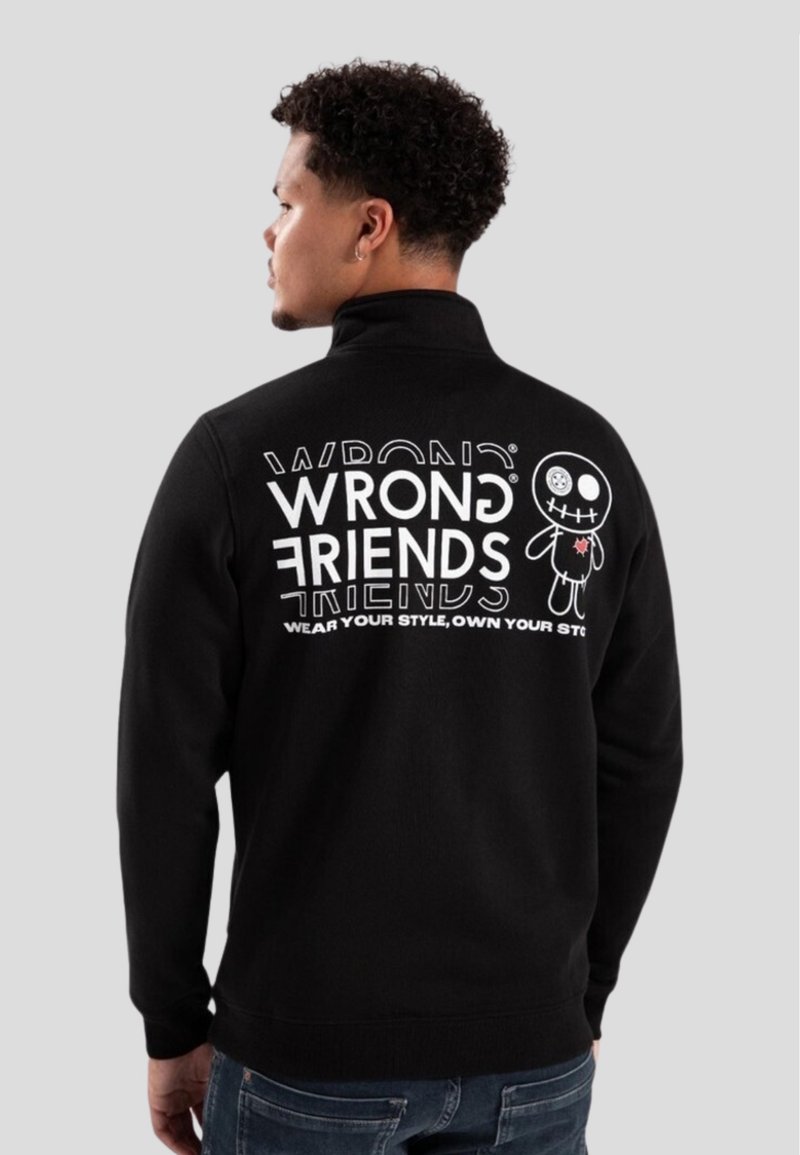 Sudadera negra con el texto gráfico en blanco "WRONG FRIENDS" y un personaje de dibujos animados en la parte posterior. Cuello alto y puños de canalé.