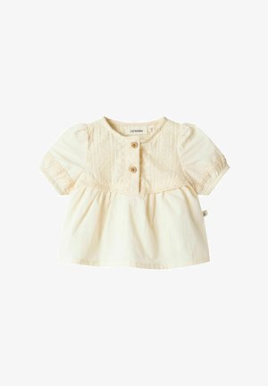 Cream-colored cotton top with short puff sleeves, featuring a button-front closure and lace detailing along the yoke and waist.