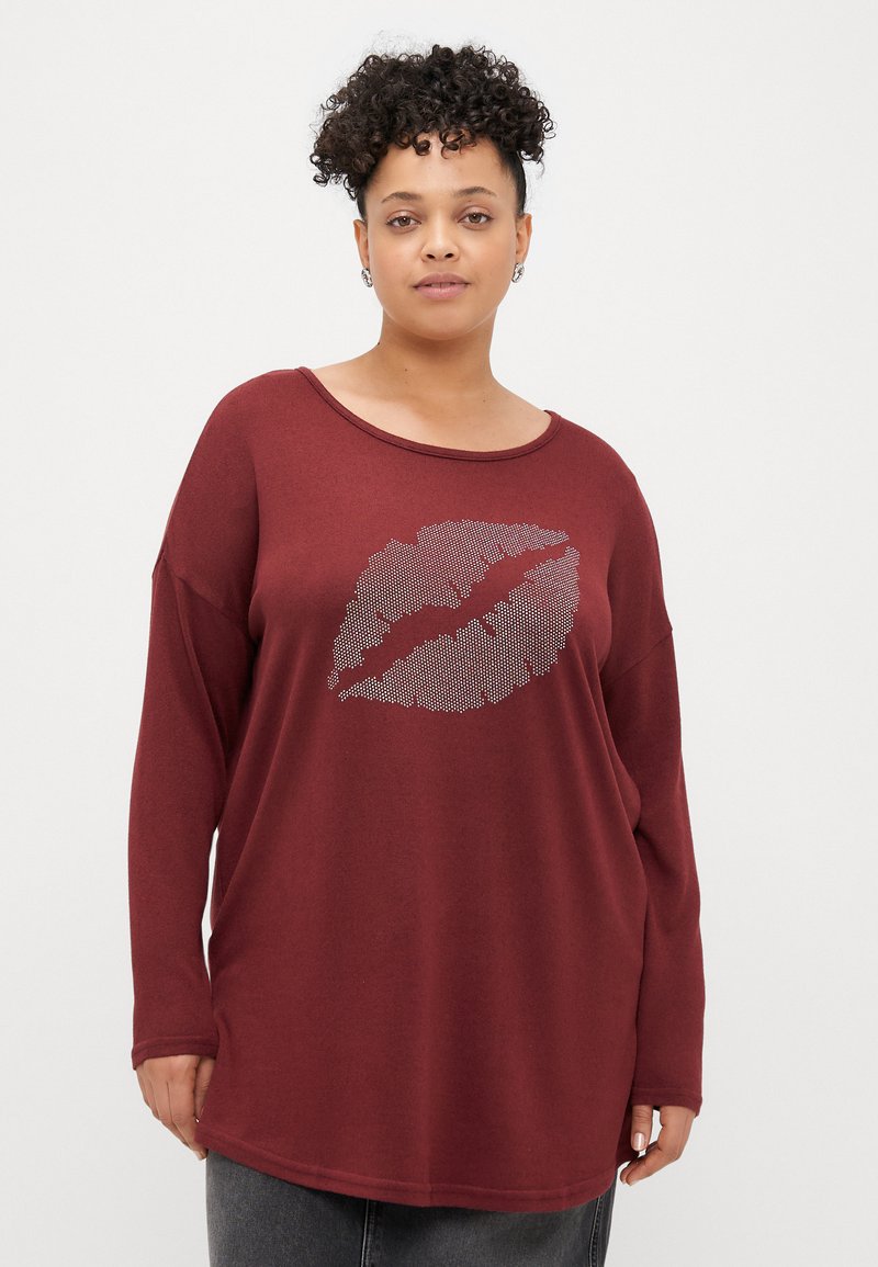 Sweatshirt de manga longa de cor bordo com corte relaxado, apresentando uma impressão de lábios em strass prateado na parte da frente e um tecido suave e texturizado.