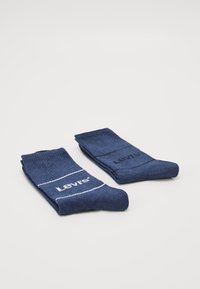 Tamsiai mėlynos medvilnės kojinės su baltu Levi's logotipu ir juostelėmis; su raukšlėta tekstūra ir vidutinio ilgio, tinkamos kasdieniam dėvėjimui.
