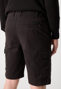 Mørkebrune cargo shorts laget av slitesterkt stoff med sidelommer, baklommer og elastisk midje for komfort.