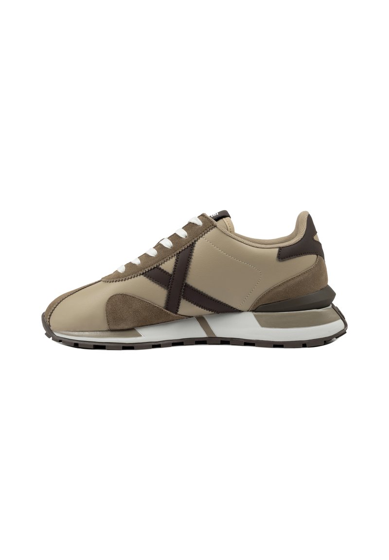 Zapatillas beige y marrón con una combinación de materiales de cuero y ante, presentando un diseño geométrico y una suela de goma con acentos contrastantes.