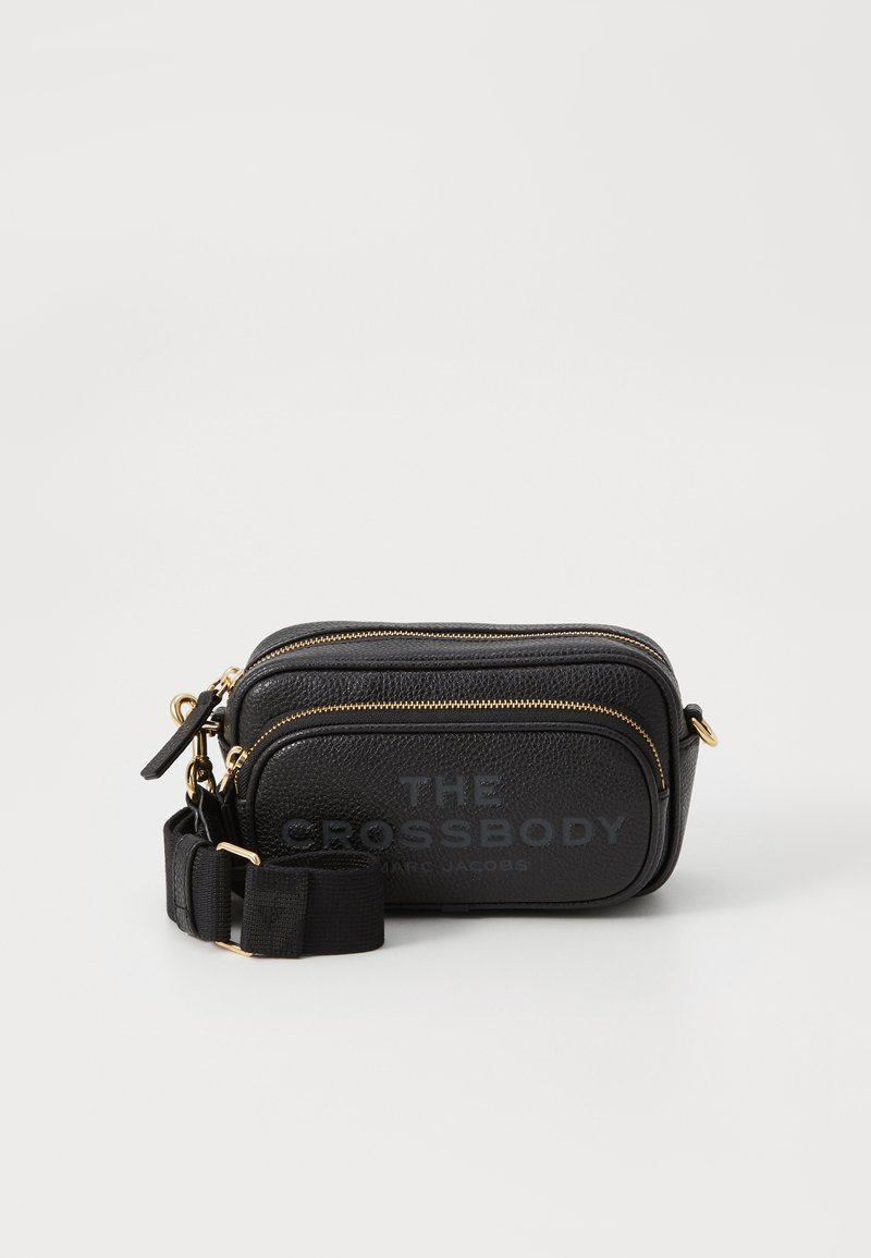 Borsa a tracolla in pelle nera texturizzata con zip dorate e tracolla regolabile nera, etichettata "THE CROSSBODY MARC JACOBS."