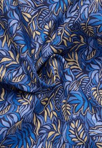 Blauw en gele bladachtige stof met een gestructureerde uitstraling, met een herhalend bloemmotief op een donkerblauwe achtergrond.