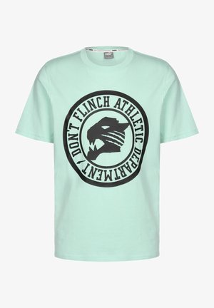 Tricou din bumbac de culoare verde mentă, prezentând o grafică circulară mare de culoare neagră cu o față de animal stilizată și textul "NU CLIPII DEPARTAMENTUL SPORTIV."