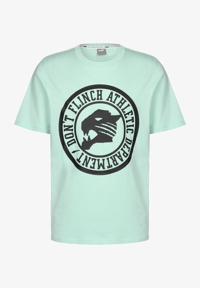 Mėtinės žalios medvilnės marškinėliai su dideliu juodu apskritimu, kuriame pavaizduotas stilizuotas gyvūno veidas ir tekstas "NEPAGYDYK ATLETIKOS DEPARTAMENTAS."