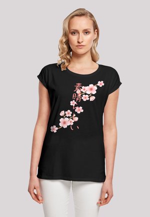 Black t-shirt with short sleeves featuring pink cherry blossom designs and Japanese characters. Soft fabric, relaxed fit, rounded neckline.