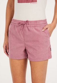 Różowe sztruksowe szorty z elastycznym paskiem w talii, sznurowaniem i bocznymi kieszeniami. Teksturowana tkanina z poziomymi paskami.